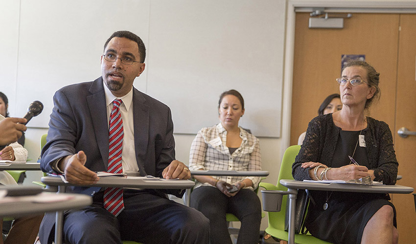 A photo of Deputy Secretary of Education John King and Undocumented Student Advisor Nancy Jodaitis during a roundtable discussion.